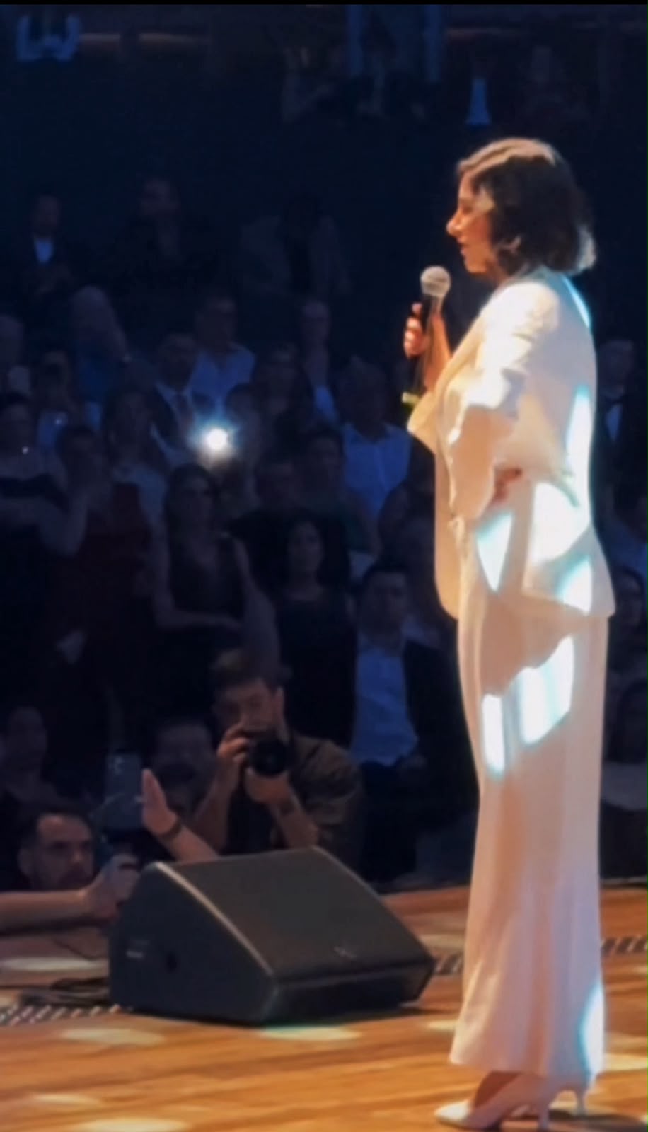 Thaísa M. Nassif palestrando em palco diante de grande plateia