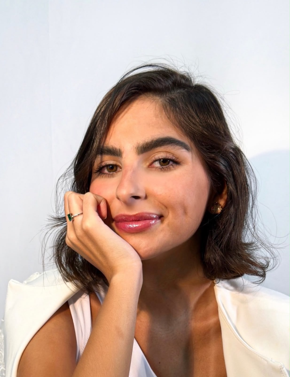 Thaísa M. Nassif sorrindo com blazer branco
